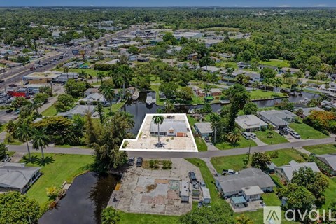 An aerial view of a property with a swimming pool surrounded by trees and buildings.