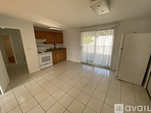 A kitchen with white tiled floors and wooden cabinets.
