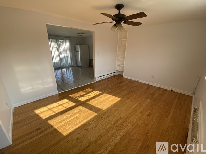 A room with wooden flooring and a ceiling fan.