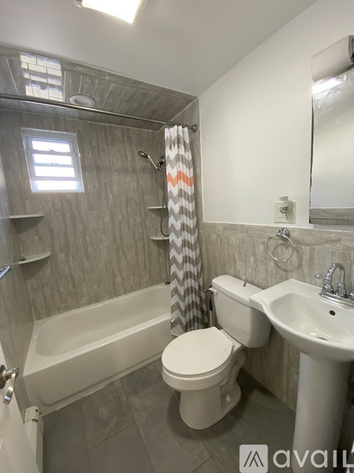 A bathroom with a toilet, sink, and bathtub.