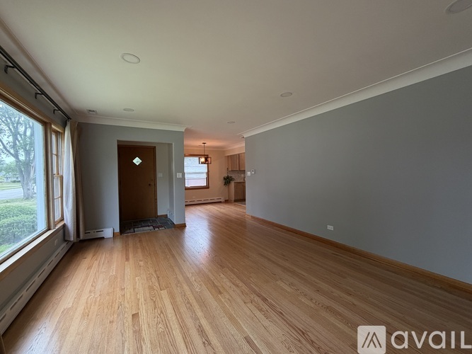 A spacious room with wooden floors and a door in the background.