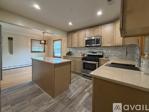 A kitchen with wooden cabinets and a stone backsplash.