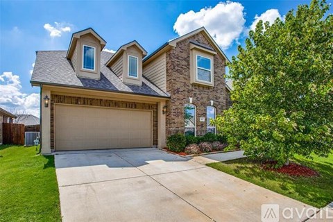 A house with a garage and a driveway in front of it.