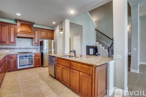 A kitchen with wooden cabinets and a marble countertop.
