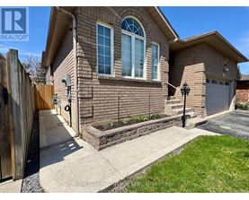 A house with a brown brick exterior and a white garage door.