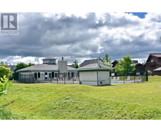 A house with a grey roof and a fence in front of it.