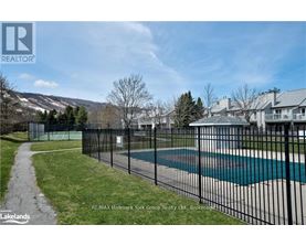A pool surrounded by a black fence with a mountain in the background.