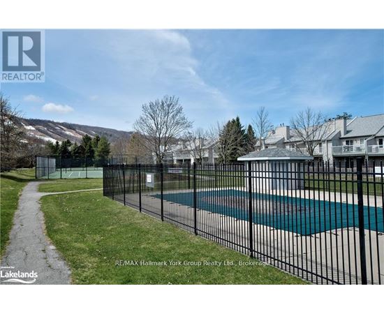 A pool surrounded by a black fence with a mountain in the background.