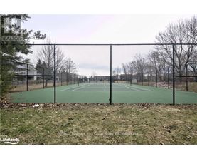 A tennis court surrounded by a black fence.