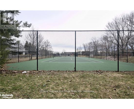 A tennis court surrounded by a black fence.