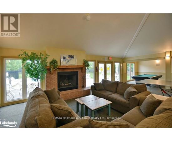 A living room with a pool table and a fireplace.
