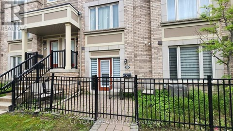 A brick building with a black fence in front.