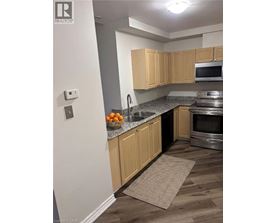 A kitchen with wooden cabinets and a stainless steel oven.