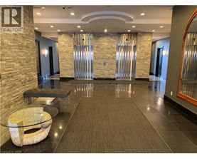 A spacious hallway with a stone wall and a glass table.