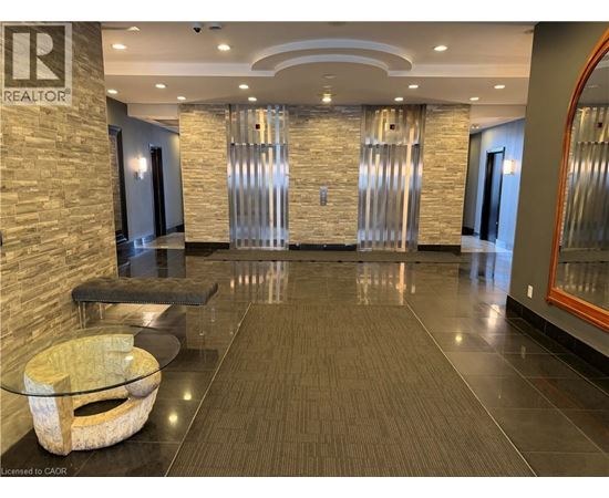 A spacious hallway with a stone wall and a glass table.