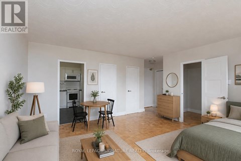 A well-lit, spacious bedroom with a large bed and a separate dining area.