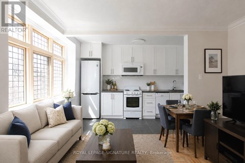 A well-lit, modern kitchen with white appliances and a dining area with a table set for two.