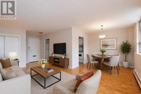 A living room with a white couch, a coffee table, and a television.