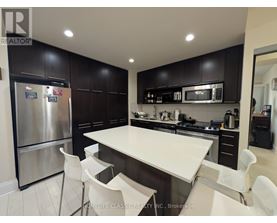 A modern kitchen with a large island and stainless steel appliances.