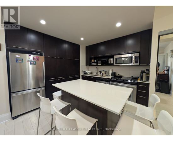 A modern kitchen with a large island and stainless steel appliances.