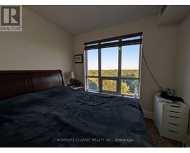 A bedroom with a large bed and a window overlooking a field.