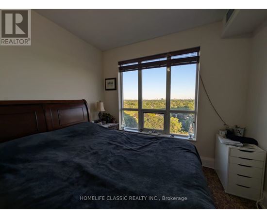 A bedroom with a large bed and a window overlooking a field.