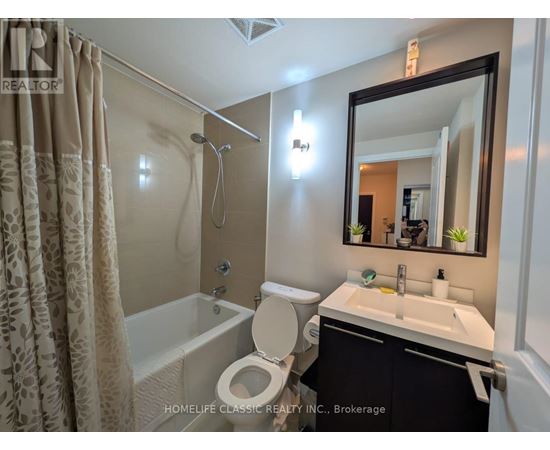 A bathroom with a toilet, sink, and shower.