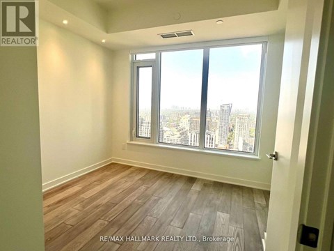 A room with a view of the city through large windows.
