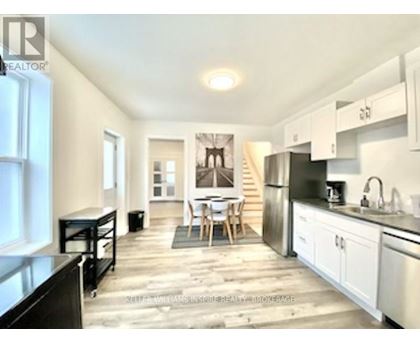 A kitchen with white cabinets and a black refrigerator.