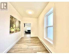 A hallway with a painting on the wall and a car in the background.