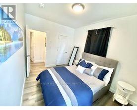 A bedroom with a large bed and a poster on the wall.