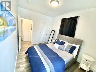 A bedroom with a large bed and a poster on the wall.