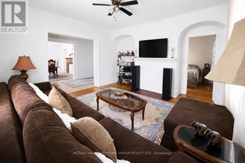 A living room with a brown couch and a flat screen TV mounted on the wall.