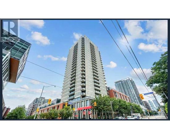 A tall building with many windows is the focal point of the image.