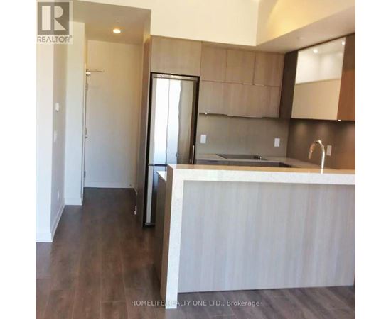 A modern kitchen with dark wood floors and white countertops.