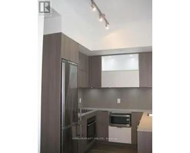A modern kitchen with a refrigerator, oven, and microwave.