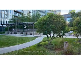A tree in a grassy area with a building in the background.