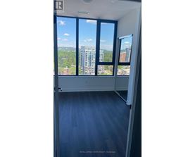 A room with a view of the cityscape through large windows.