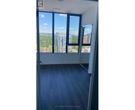 A room with a view of the cityscape through large windows.