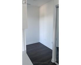 A white room with a wooden floor and a white door.