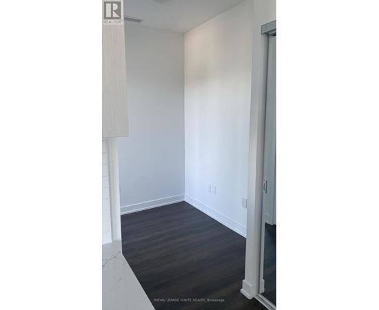 A white room with a wooden floor and a white door.