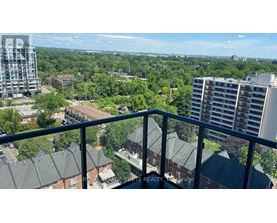 A balcony overlooks a residential area with trees and buildings.