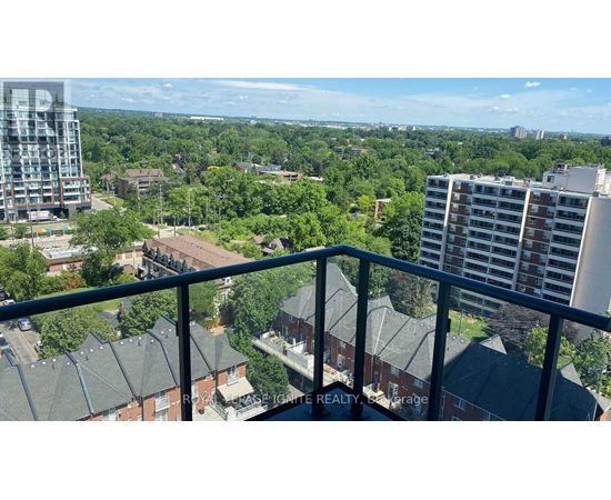 A balcony overlooks a residential area with trees and buildings.