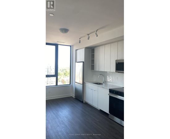 A kitchen with white cabinets and a black stove top oven.