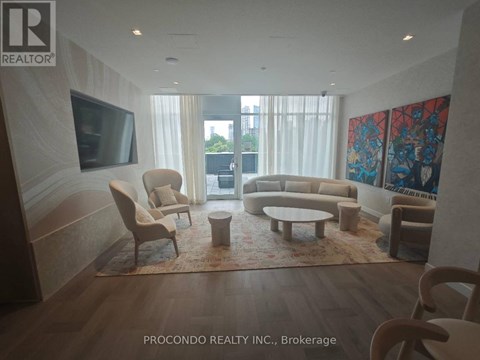 A living room with a flat screen TV and a large painting on the wall.