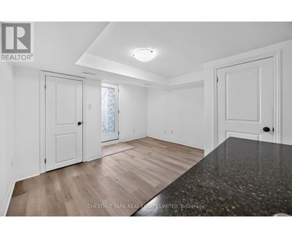A spacious room with white walls and a large window.