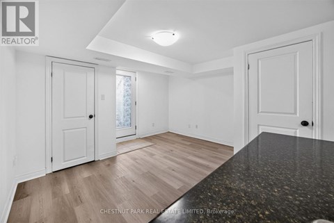 A spacious room with white walls and a large window.
