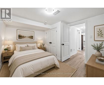 A bedroom with a large bed and a painting on the wall.