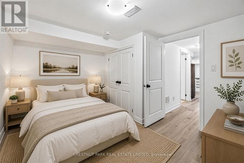 A bedroom with a large bed and a painting on the wall.