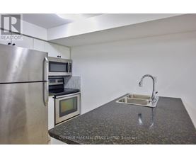 A kitchen with a granite countertop and stainless steel appliances.